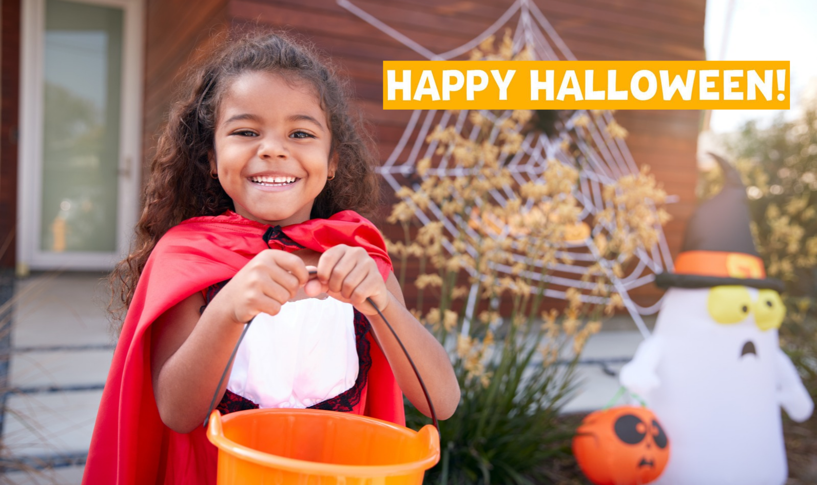 Image of child dressed in a cape and holding a bucket for Halloween trick-or-treating.