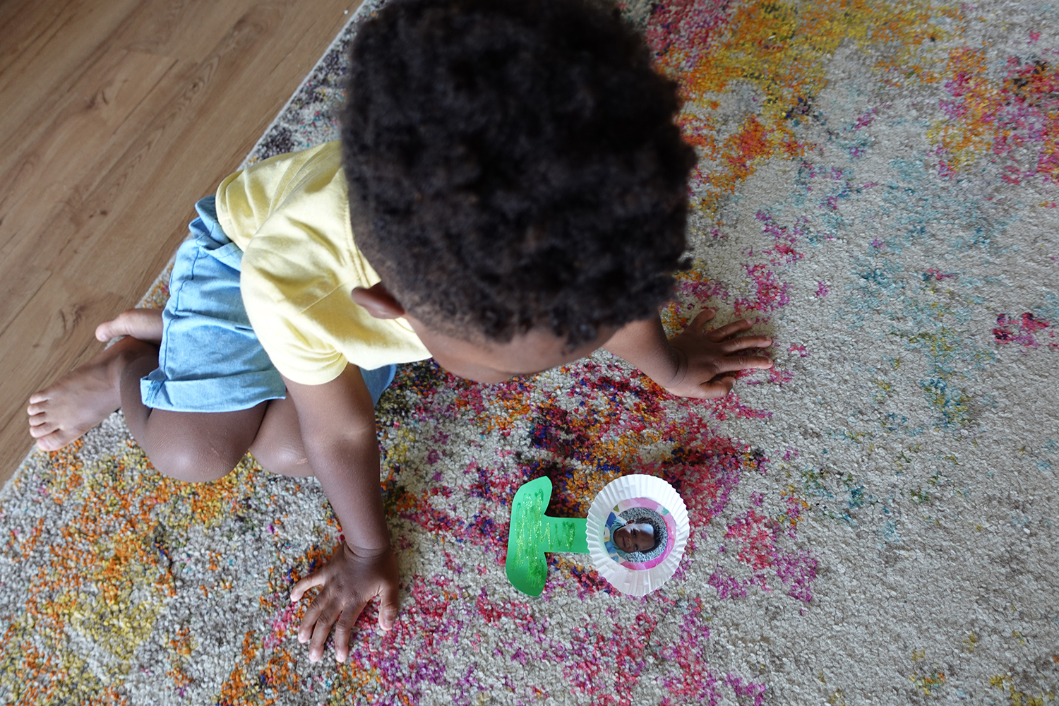Young child looking at flower craft.